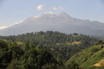 Mexico, Puebla, View of Ixtaccihuatl volcano with wooded parkland in foreground.