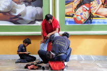 Mexico, Puebla, Shoeshine stand in front of posters.