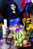 Mexico, Michoacan, Patzcuaro, Dia de los Muertos, Day of the Dead, altar with figures, food, candles and flowers.