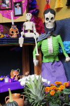 Mexico, Michoacan, Patzcuaro, Dia de los Muertos, Day of the Dead, altar with skeleton figures, flowers and colourful paper decorations.