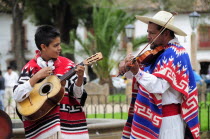 Mexico, Michoacan, Patzcuaro, Musicians playing violin and guitar during performance of Danza de los Viejitos or Dance of the Little Old Men in Plaza Vasco de Quiroga.