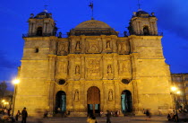 Mexico, Oaxaca, Baroque exterior facade of the Cathedral at night with people in the square in foreground.