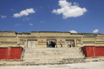 Mexico, Oaxaca, Mitla archaeological site, Templo de las Columnas with tourist visitors standing at top of steps to entrance.