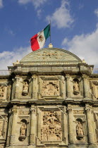 Mexico, Oaxaca, Cathedral facade with Mexican flag flying from roof.