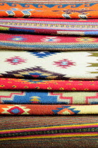 Mexico, Oaxaca, Detail of stacked weavings and carpets by Tomas and Arnulfo Mendoza.