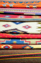 Mexico, Oaxaca, Detail of stacked weavings and carpets by Tomas and Arnulfo Mendoza.