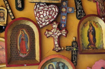 Mexico, Michoacan, Patzcuaro,  Religious, kitsch art displayed on yellow painted wall.