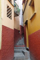 Mexico, Bajio, Guanajuato, Callejon del Beso, Narrow street with steep flight of steps ascending between painted building exteriors.