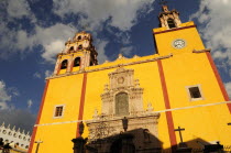 Mexico, Bajio, Guanajuato, Basilica de Nuestra Senora de Guanajuato or Basilica of Our Lady of Guanajuato. Baroque, yellow painted exterior facade with clock and bell tower.