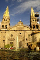 Mexico, Jalisco, Guadalajara, Plaza Guadalajara, Cathedral exterior facade and bell towers with fountain in foreground.