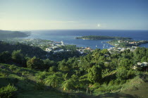 West Indies, Jamaica, Port Antonio, view over tree covered hillside towards waterside town and harbour.