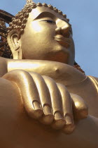 Thailand, Religion, Buddhism, angled view of large golden seated buddha statue.