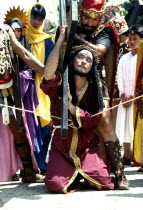 Philippines, Marinduque Island, Boac worshipper dressed as christ carrying cross during the moriones festival.