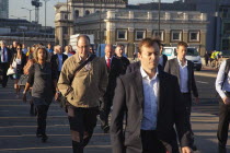 England, London, Early morning commuters crossing London Bridge towards the City Financial district.