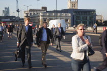 England, London, Early morning commuters crossing London Bridge towards the City Financial district.