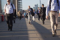 England, London, Early morning commuters crossing London Bridge towards the City Financial district.