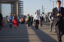 England, London, Early morning commuters crossing London Bridge towards the City Financial district.