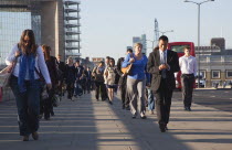 England, London, Early morning commuters crossing London Bridge towards the City Financial district.