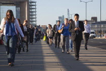 England, London, Early morning commuters crossing London Bridge towards the City Financial district.