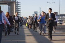 England, London, Early morning commuters crossing London Bridge towards the City Financial district.