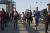 England, London, Early morning commuters crossing London Bridge towards the City Financial district.