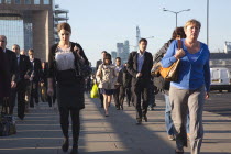 England, London, Early morning commuters crossing London Bridge towards the City Financial district.