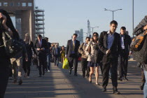 England, London, Early morning commuters crossing London Bridge towards the City Financial district.