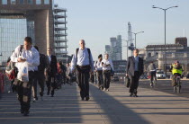 England, London, Early morning commuters crossing London Bridge towards the City Financial district.