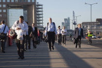 England, London, Early morning commuters crossing London Bridge towards the City Financial district.