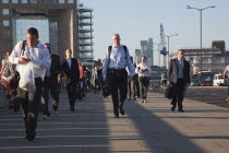 England, London, Early morning commuters crossing London Bridge towards the City Financial district.