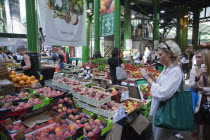 England, London, Southwark, Borough Market, Londons oldest fresh fruit and vegetable market, Tourist taking photograph with smart phone.