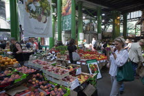 England, London, Southwark, Borough Market, Londons oldest fresh fruit and vegetable market., tourist taking photograph with smart phone.