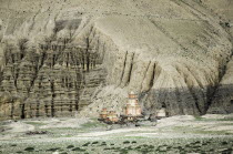 Nepal, Upper Mustang, Distant Gompas and eroded rocks near Dhakmar village.