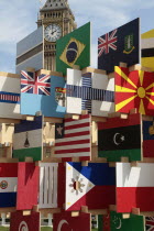 England, London, Parliament Square, Sculpture containing flags of competing Olympic nations with Big Ben behind.