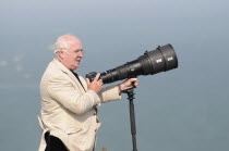 England, East Sussex, Beachy Head, Plane enthusiast photographing air display with long lens on a monopod during the Airbourne airshow.