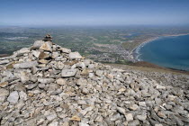 Ireland, North, Co.Down, Mourne Mountains, A cairn on the summit of Slieve Donard with Newcastle and its beach in the background.