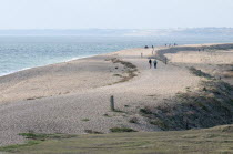 England, Hampshire, Milford on Sea, People walking along Hurst spit, a 1.5 mile long shingle ridge.