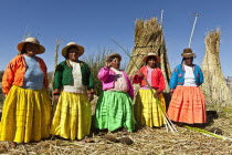 Peru, Puno, Lake Titicaca, Women in colorful clothing on Grass Island.