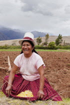 Peru, Chinchero, Peruvian female farmer showing the corn that she is planting.