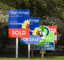 Business, Finance, Real Estate, Estate agents signs on posts advertising property for sale and sold.