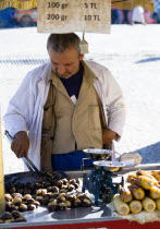 Turkey, Istanbul, Sultanahmet, Man selling roast chestnuts and sweetcorn in the street.