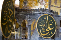 Turkey, Istanbul, Sultanahmet, Haghia Sophia Sightseeing tourists in the North Gallery with Koranic Islamic calligraphic roundels of Arab text.