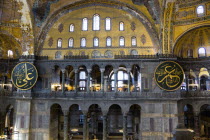 Turkey, Istanbul, Sultanahmet, Haghia Sophia Sightseeing tourists in the North Gallery with Koranic Islamic calligraphic roundels of Arab text.