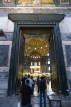 Turkey, Istanbul, Sultanahmet, Haghia Sophia People walking through the Imperial Gate with mosaics above and the Nave of the Cathedral beyond.