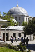 Turkey, Istanbul, Sultanahmet, Haghia Sophia Sightseeing tourists in the grounds with the dome towering above them.
