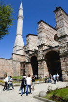 Turkey, Istanbul, Sultanahmet, Haghia Sophia Minaret with sightseeing tourists entering the Outer Narthex leading to the Imperial Gate entrance.