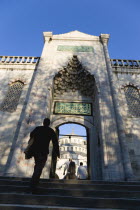 Turkey, Istanbul, Sultanahmet Camii, The Blue Mosque Courtyard and dome seen through the exit to the Hippodrome with people entering through doorway.