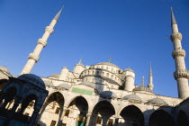 Turkey, Istanbul, Sultanahmet Camii, The Blue Mosque domes seen from the Courtyard with Arabic text from the Koran in green and the Absolution Fountain in the foreground.