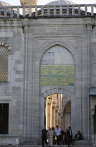 Turkey, Istanbul, Sultanahmet Camii, The Blue Mosque with people passing through the entrance to the Courtyard beneath Arabic text from the Koran.