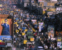 Crowded street of Chandni Chowk with trishaws  trucks and  people with a roadside cinema hoarding